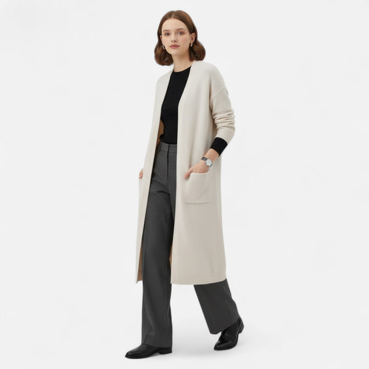 Modell som bär lång beige damcardigan framifrån med svarta byxor