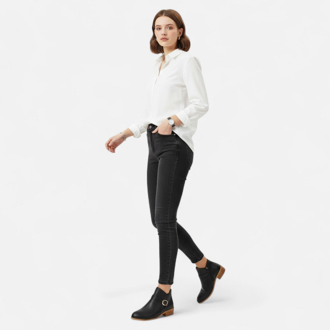 Kvinna som bär svarta ankelstövletter med skjorta och jeans