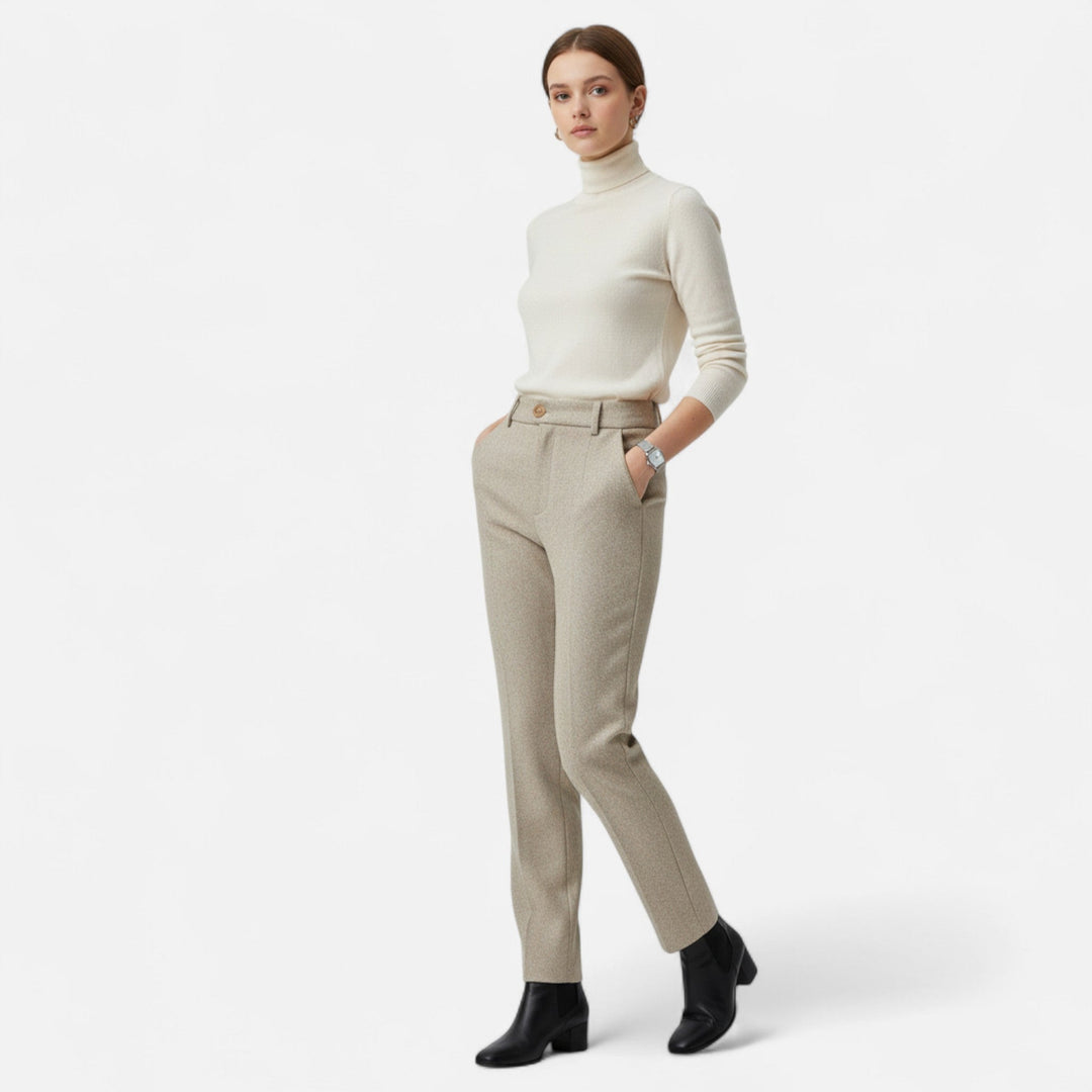 Helhetsbild av modell i beige högmidjade pennbyxor och polotröja