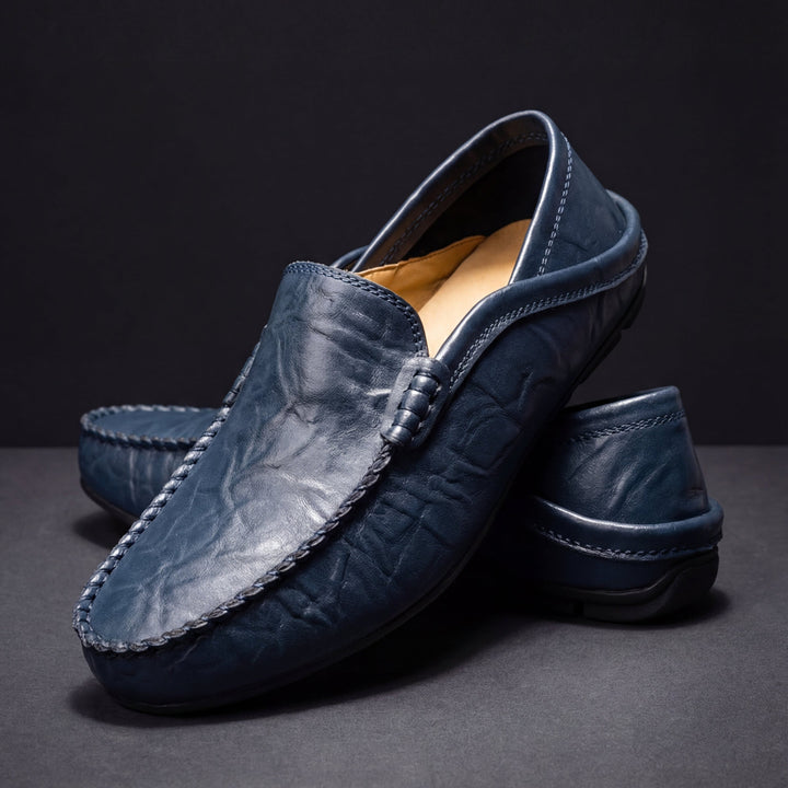 Antoine loafers i marinblått material uppställda i studion