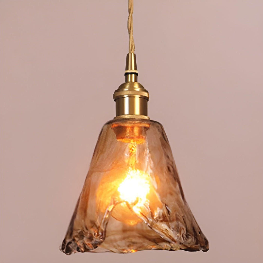 Bärnstensfärgad hänglampa i glas med tänd glödlampa