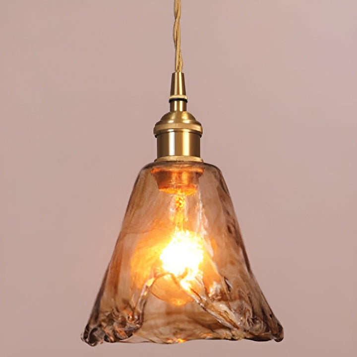 Bärnstensfärgad hänglampa i glas med tänd glödlampa