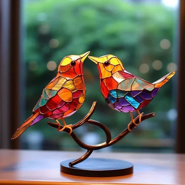 Två handgjorda glasfåglar tillsammans på en metallgren