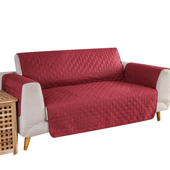Grått soffskydd som skyddar vardagsrummets soffa mot fläckar och spill