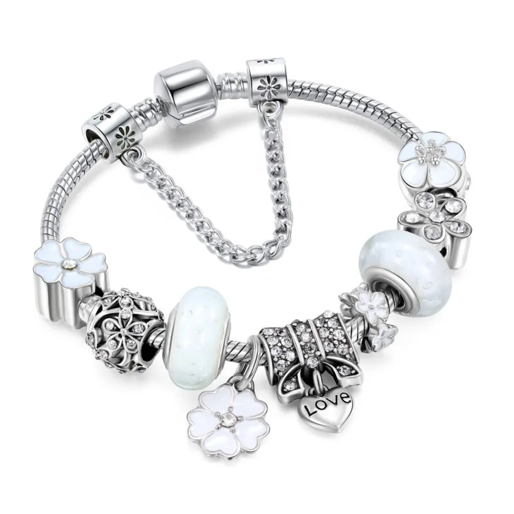 Närbild på silverarmband för dam med detaljrika charm-detaljer