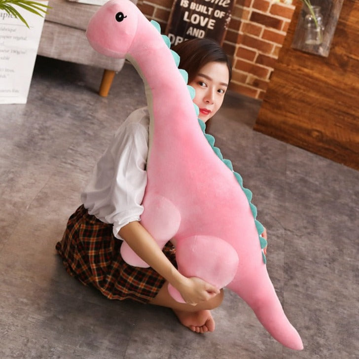 Barn som kramar det stora mjukdjuret i form av en dinosaurie i barnrummet