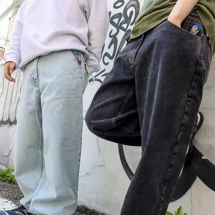 Detaljbild på sömmar och bälteshällor på trendiga vida jeans för män