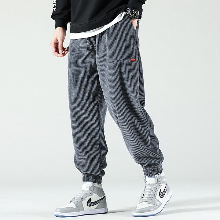 Man i grå byxor med höga sneakers