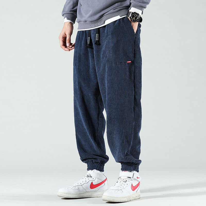 Man i mörkblå byxor med vita sneakers