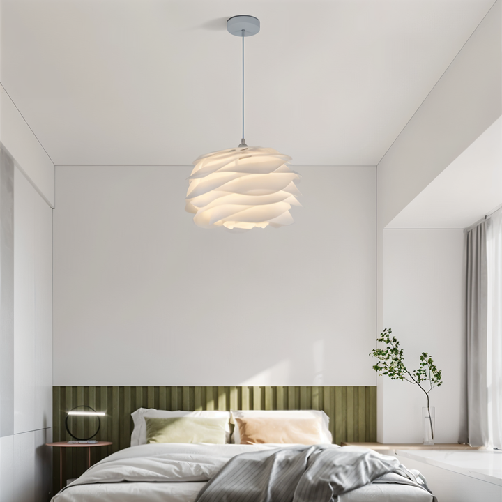 Aurora taklampa i vit blomdesign hängande över en bäddad säng i ett ljust sovrum
