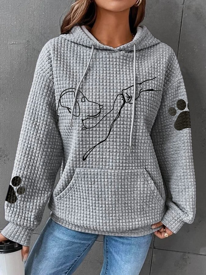 Detaljbild på hundtryck och textur på våfflad damtröja med luva