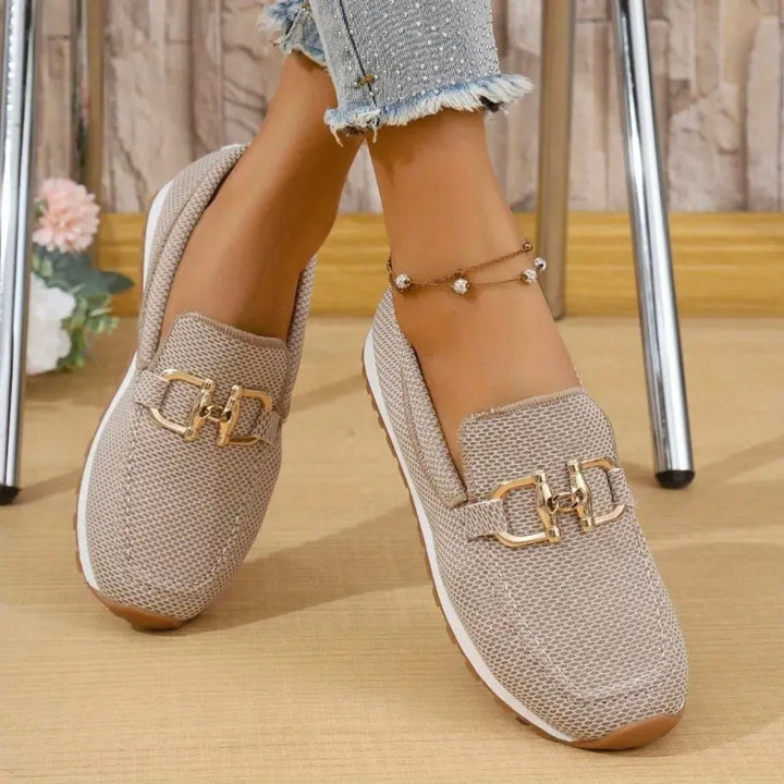 Marie bekväma beige sneakers på modell med gulddetaljer