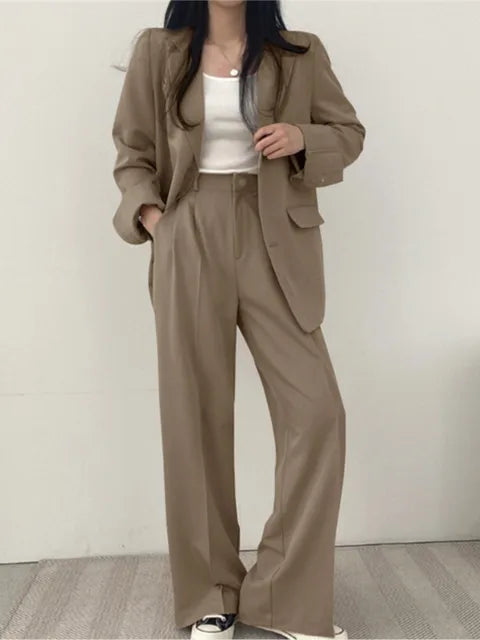 Helhetsbild av elegant damkostym med blazer och vida ben