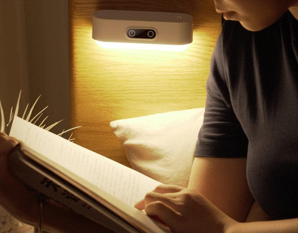 Person som läser en bok med varmt ljus från nattlampan
