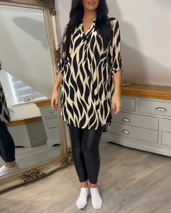 Kvinna som bär mönstrad lång blus i beige framför spegel