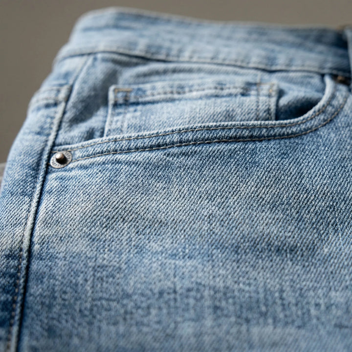 Närbild på fickor och sömmar på ljusa herrjeans Irvin