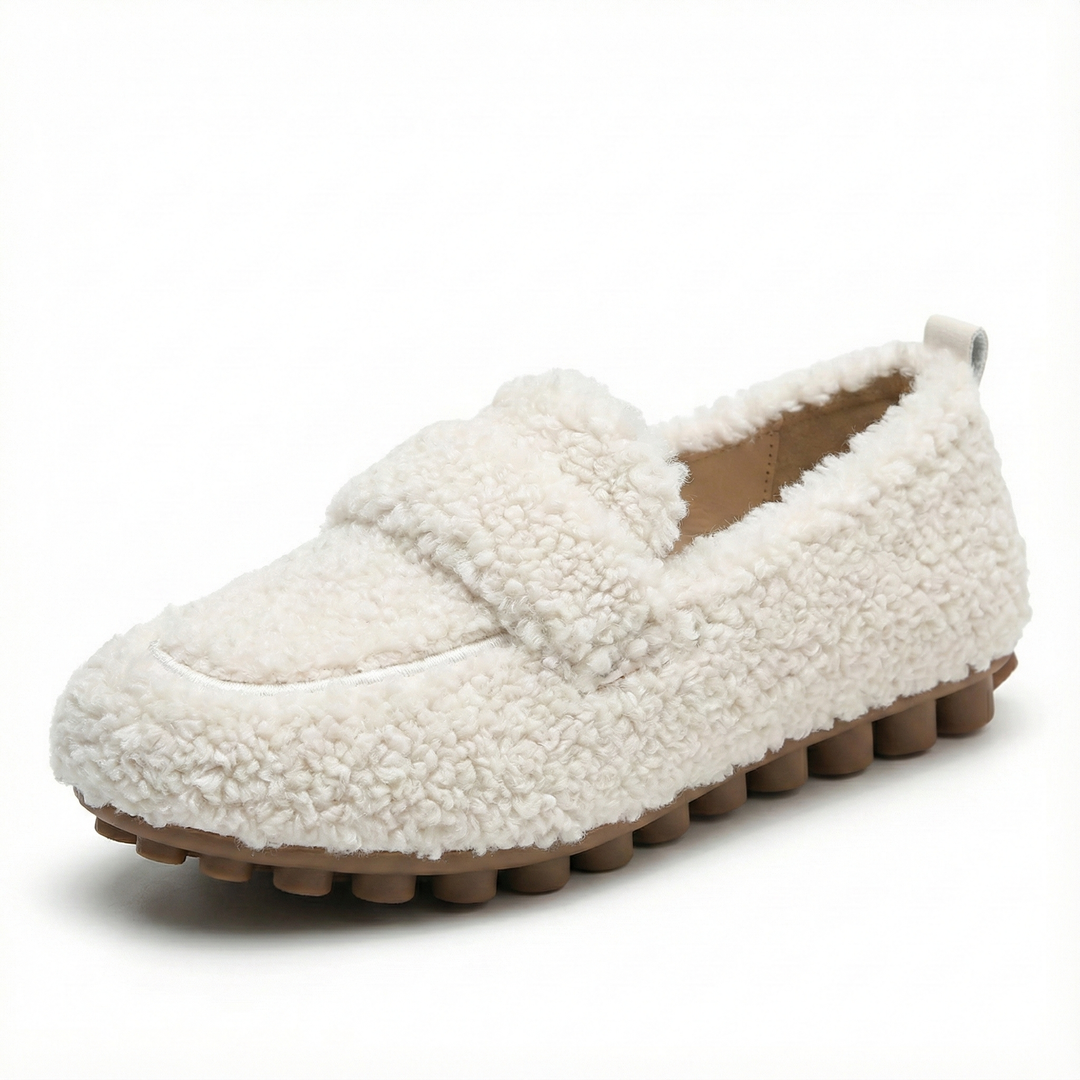 Beige damloafers med plyschutseende och räfflad sula mot vit bakgrund