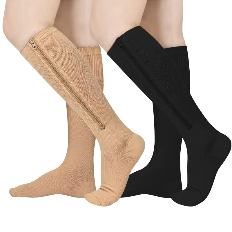 Person som bär beige och svarta stödstrumpor med dragkedja
