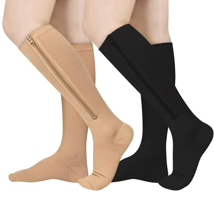Person som bär beige och svarta stödstrumpor med dragkedja