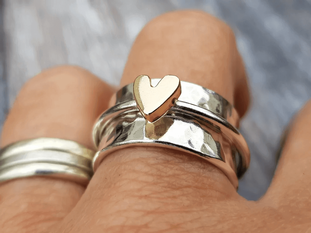 Närbild på damring i silver med hjärteffekter på finger