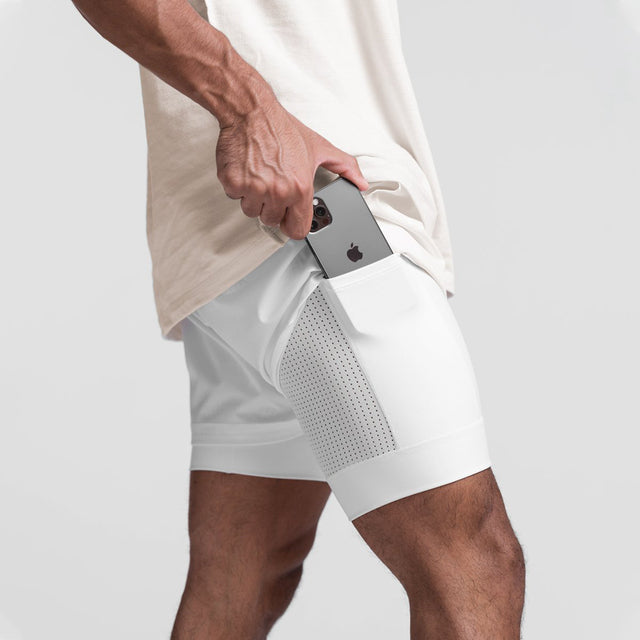 Närbild på vit sportshort med mobiltelefon i lårfickan