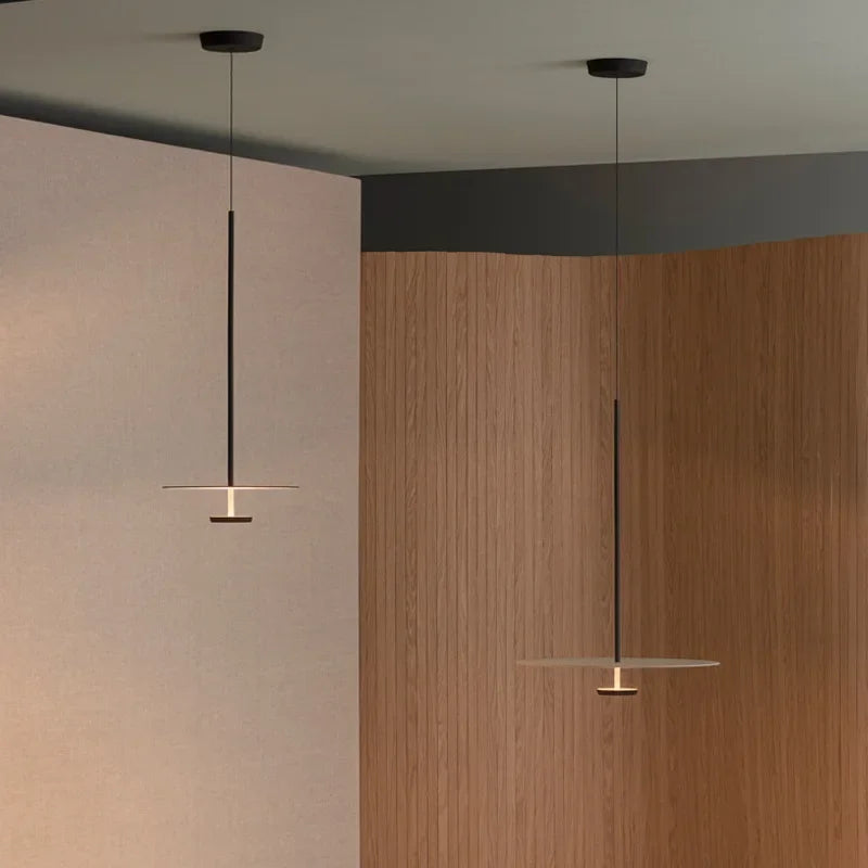 Närbild på ArcLumi moderna båglampor mot en trä- och väggpanel