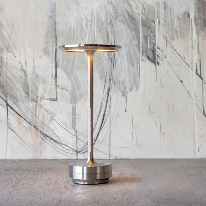 Uppladdningsbar LED-bordslampa i minimalistisk stil placerad på ett skrivbord