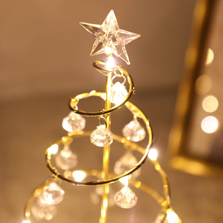 Närbild på toppen av en gyllene kristalljulgran med LED-belysning