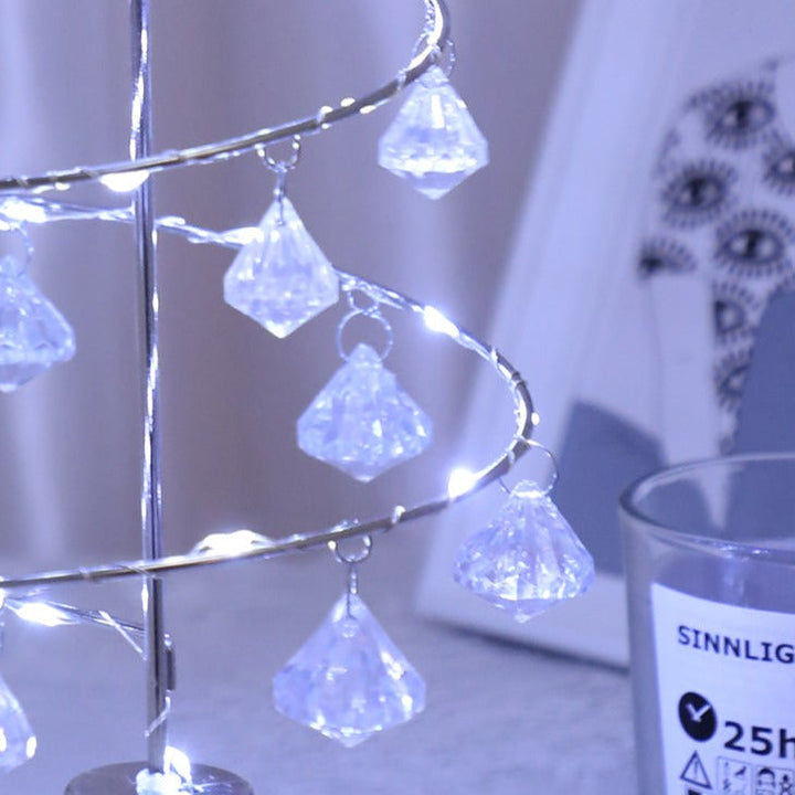 Detaljbild på hängande kristalldetaljer på en silverfärgad julgransbelysning