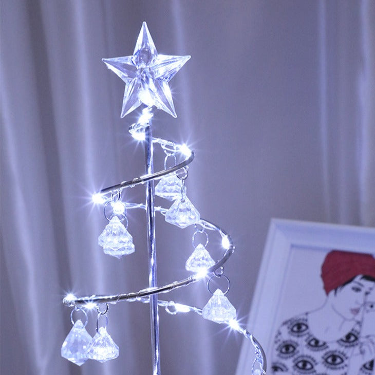 Elegant LED nattlampa formad som en julgran i kristall placerad på ett bord som juldekor