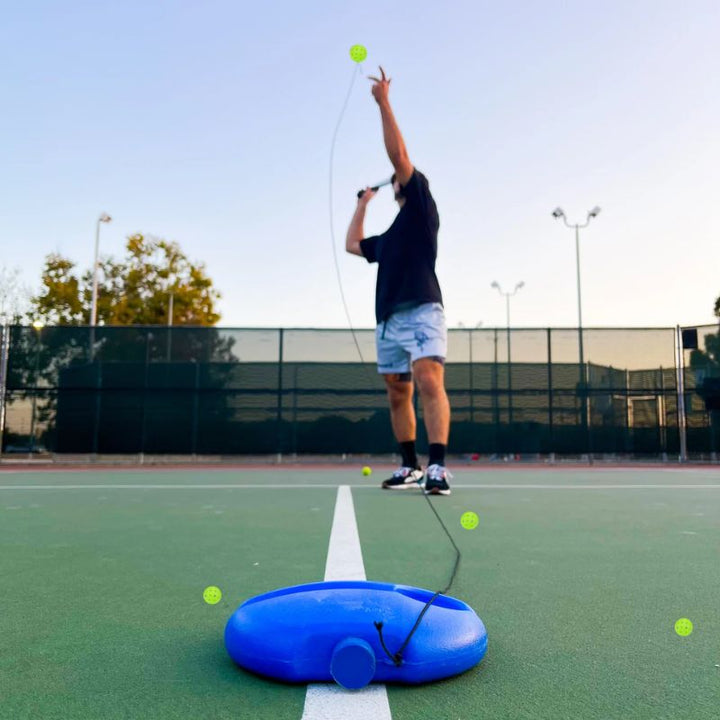 Träningsredskap för pickleball med boll och bas uppackat på gräsmatta för sport