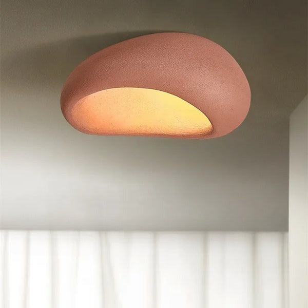 Röd wabi-sabi taklampa som sprider ett varmt sken i ett modernt hem