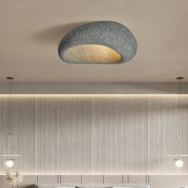 Minimalistisk grå wabi-sabi taklampa monterad i taket i ett modernt sovrum