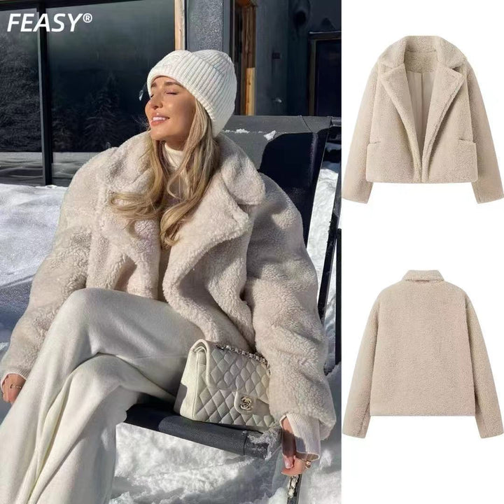 Kvinna i vit mössa som bär beige teddyjacka utomhus i snö