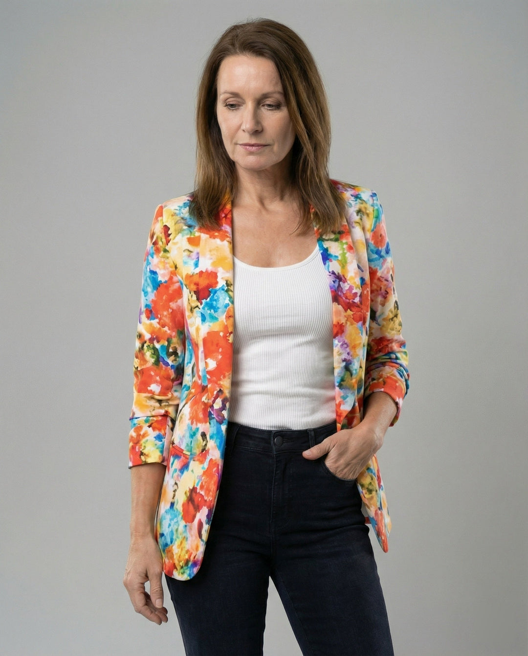 Kvinna som bär en blommig blazer med öppen front och lång ärm