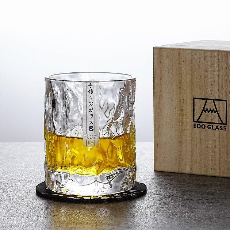 Handgjort Edo Kiriko whiskyglas med glaciärdesign bredvid en trälåda