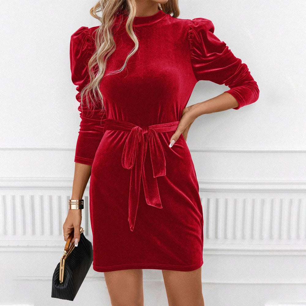 Närbild på röd sammetklänning med ståkrage och knytbälte