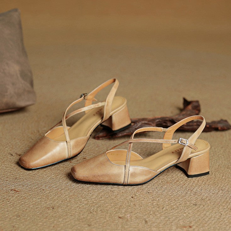 Svarta slingback-pumps i läder med korslagda remmar ovanifrån