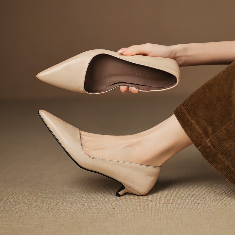 Beige damklackskor med låg kitten heel i handen