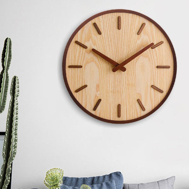 Närbild på minimalistisk valnöt väggklocka som visar urtavla och visare