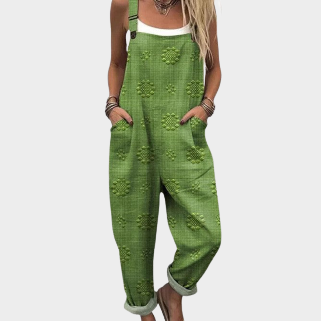 Dam bär grön mönstrad rymlig jumpsuit med hängslen och fickor