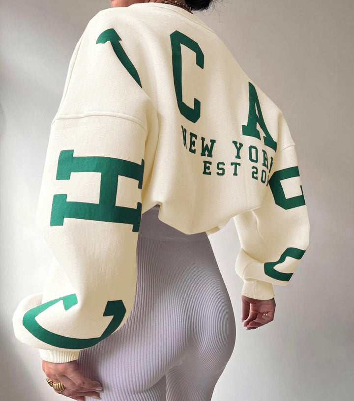 Baksida av krämvit sweatshirt med tryck och text New York