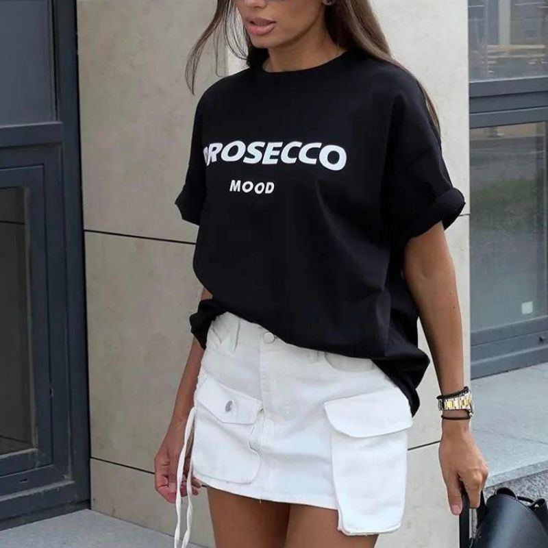 Kvinna som bär en svart oversized t-shirt med Prosecco Mood tryck