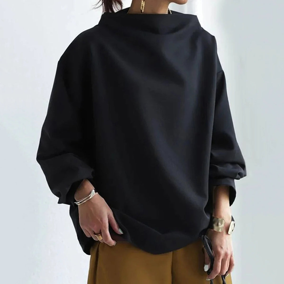 Kvinna som bär en svart oversized blus med långa ärmar