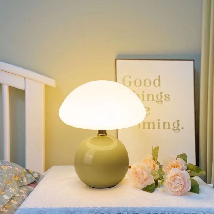 Grön keramisk svampbordslampa med dekorativa blommor på nattduksbordet