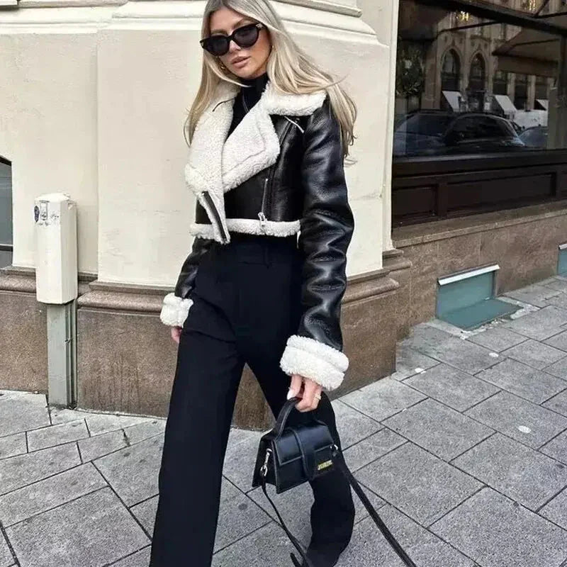 Modell i svart cropped jacka utomhus på stadsgata