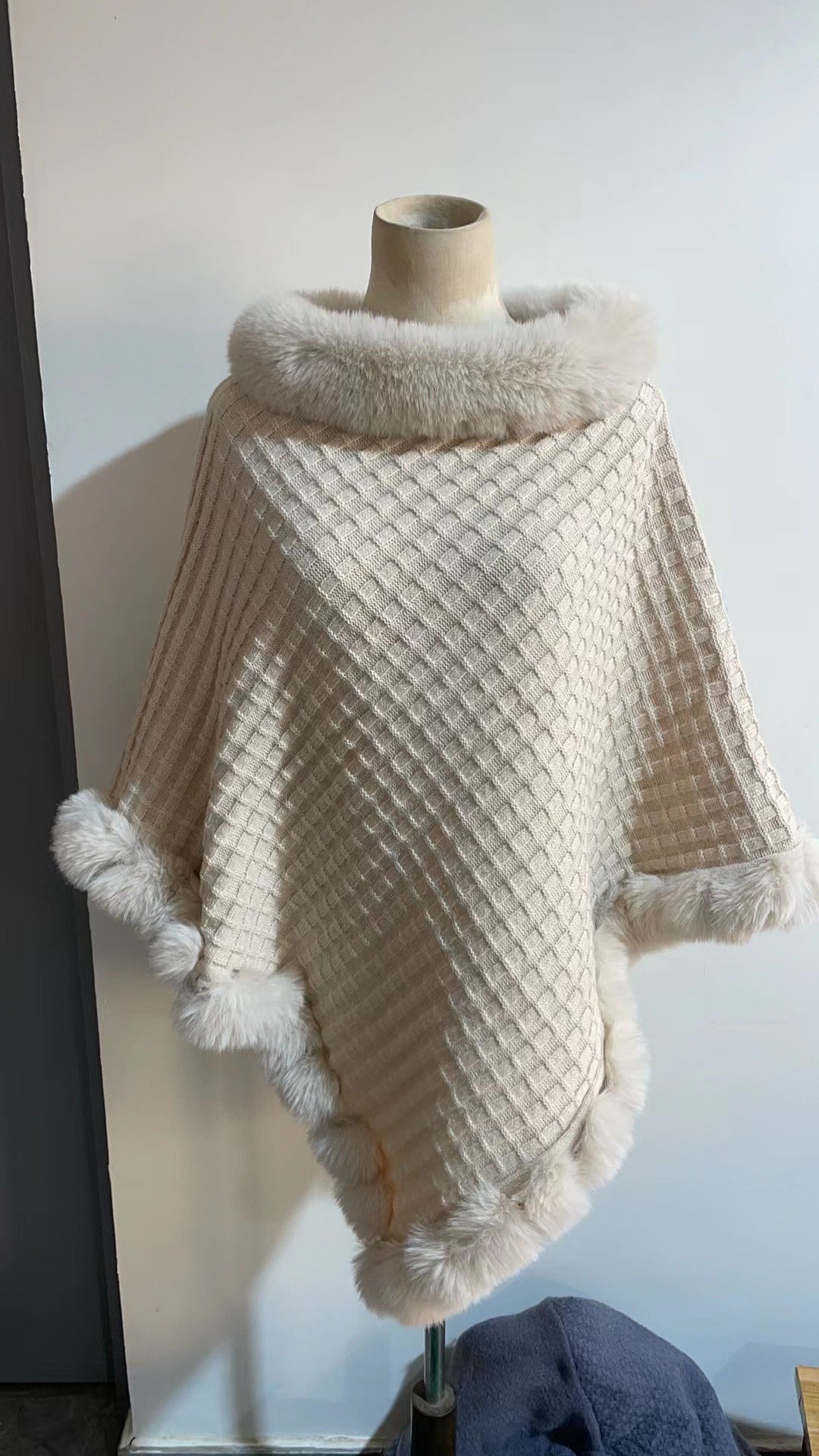 Detaljbild på elegant damponcho med mjuk och mysig textur