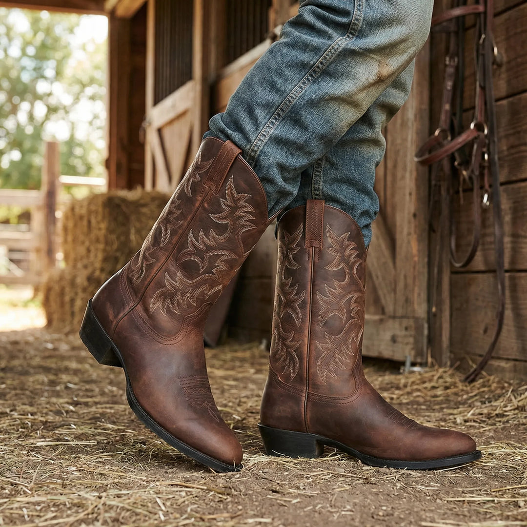 Man i jeans som bär bruna cowboystövlar utomhus