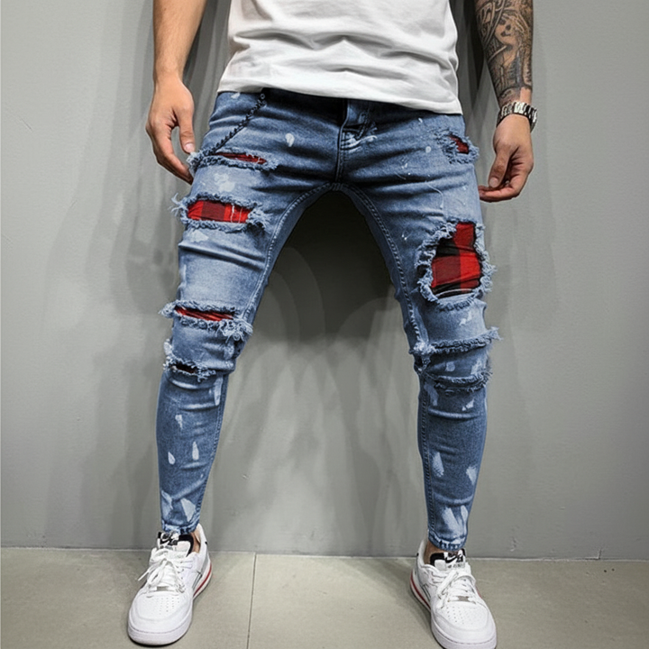 Närbild på slitningar och tyg på blå slim fit jeans för män