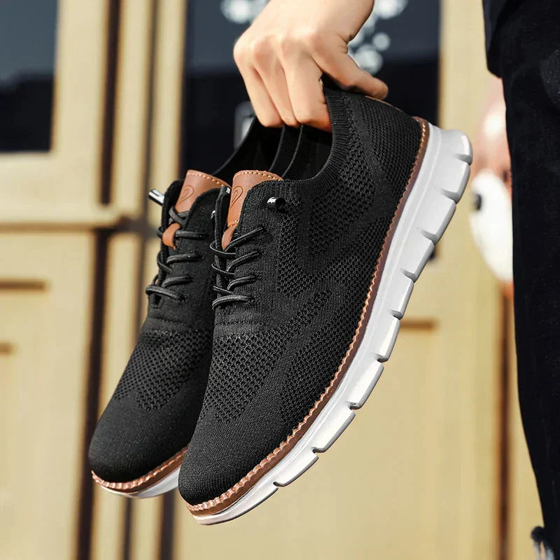 Svarta lätta herrsneakers som visas upp i handen